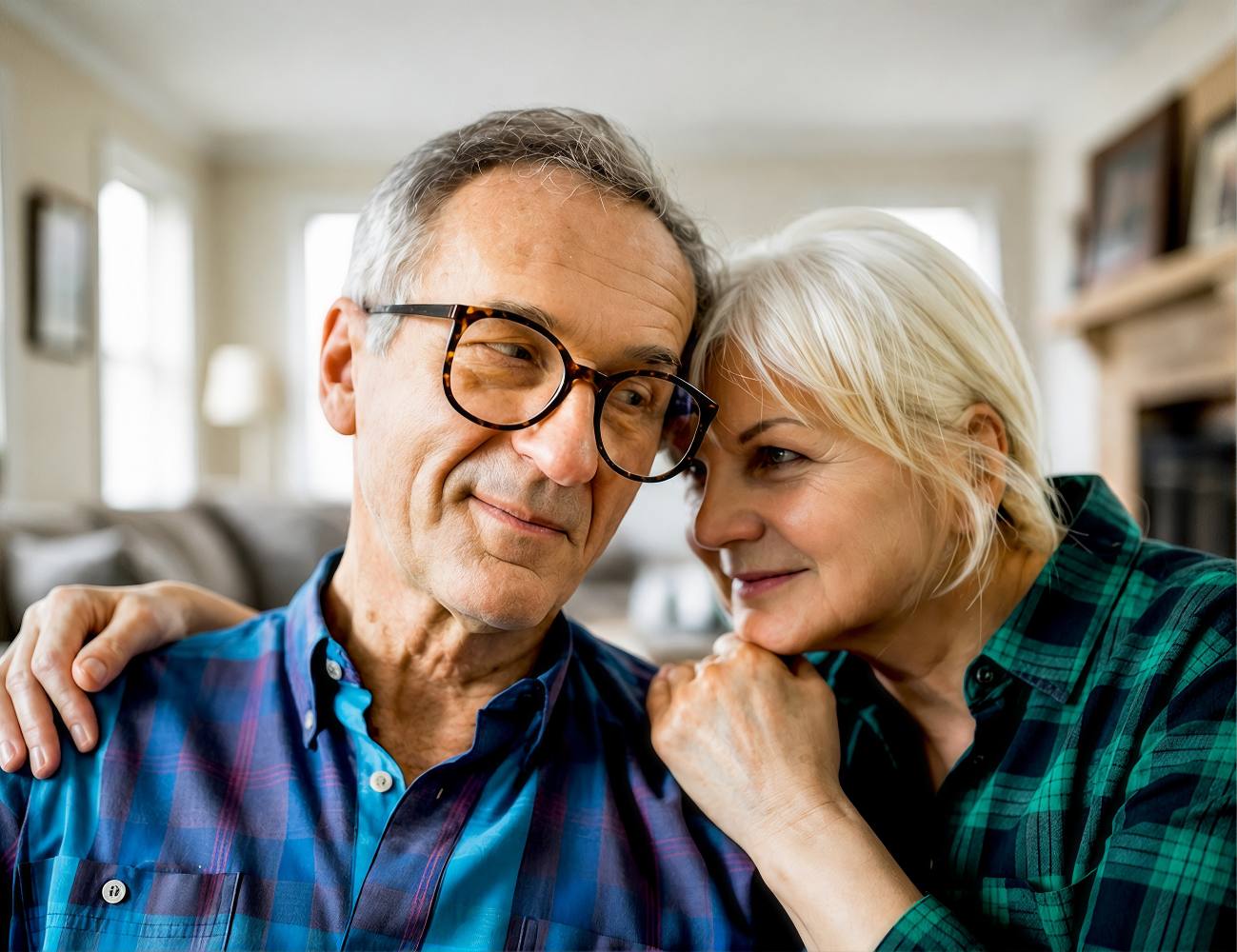 An older couple sitting closely together and smiling.